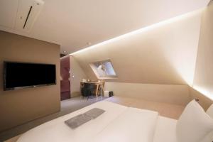 a bedroom with a bed and a tv on the wall at Seocho H hotel in Seoul