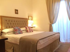アレッツォにあるMecenate 69 Suiteのベッドルーム1室(枕付きのベッド1台、窓付)
