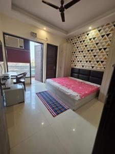 a bedroom with a bed and a table in it at Ganesh Living in Gurgaon