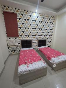two beds in a room with a wall at Ganesh Living in Gurgaon