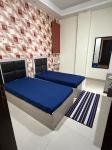 a bedroom with two beds in a room at Ganesh Living in Gurgaon