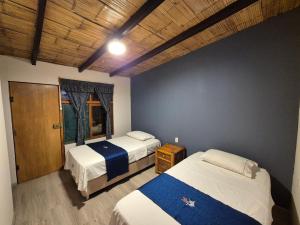 a bedroom with two beds and a wooden ceiling at Black Marlin - Restaurant and Lodge in Talara +4 photos