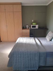 una camera con letto e forno a microonde di Coco 's Hamlet Flatlet a Prince Alfreds Hamlet