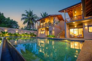 a house with a swimming pool in front of it at La Lassaura in Unawatuna