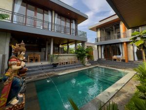 a villa with a swimming pool in front of a house at Koeluma Bali in Ubud