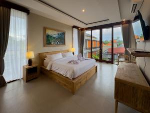 a bedroom with a large bed and a balcony at Koeluma Bali in Ubud +69 photos