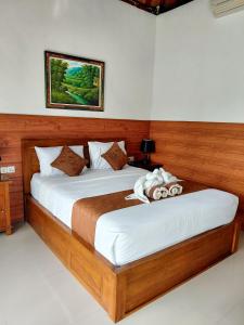 a bedroom with a large bed with white sheets at Tunjung Kuning Cottage in Nusa Penida +23 photos
