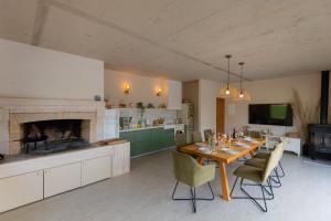 une cuisine avec une table et des chaises ainsi qu'une cheminée dans l'établissement Villa Viktoria with private pool, barbecue, gym, children's playground, à Krivodol