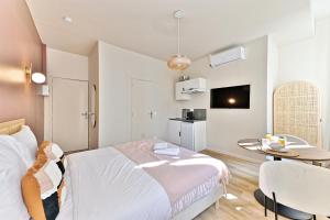 een slaapkamer met een bed en een tafel en een keuken bij Cozy air-conditioned studio Pré-St-Gervais in Pré Saint Gervais