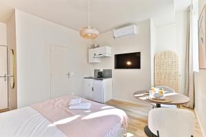 een witte kamer met een bed en een tafel bij Cozy air-conditioned studio Pré-St-Gervais in Pré Saint Gervais +25 foto's