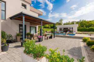 une maison avec une terrasse et une piscine dans l'établissement Villa Viktoria with private pool, barbecue, gym, children's playground, à Krivodol