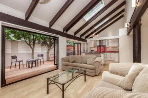 a living room with two couches and a table at Pet friendly downtown Mt Maunganui 3 bedroom home in Mount Maunganui