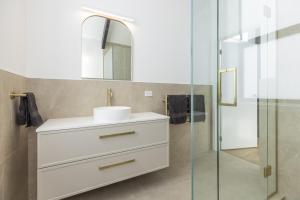 a bathroom with a sink and a shower at Pet friendly downtown Mt Maunganui 3 bedroom home in Mount Maunganui +26 photos