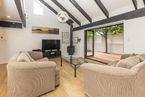 a living room with two couches and a television at Pet friendly downtown Mt Maunganui 3 bedroom home in Mount Maunganui