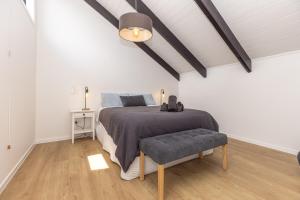 a bedroom with a bed and a table and a lamp at Pet friendly downtown Mt Maunganui 3 bedroom home in Mount Maunganui