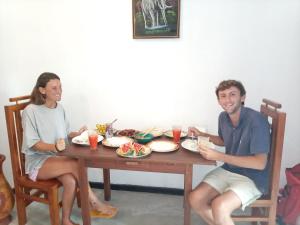 a man and woman sitting at a table with food at Sunburst Villa in Tangalle
