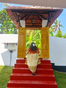 a woman walking down the red stairs at Orchid Lake View Resort in Paravūr