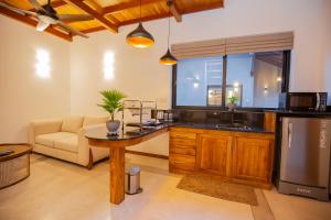 a kitchen with a table and a couch in a room at La Lassaura in Unawatuna