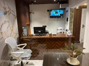 a office with a desk with a computer and a chair at PlatinumIN Guesthouse in kolkata