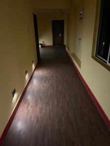 an empty hallway with a hard wood floor and lights at PlatinumIN Guesthouse in kolkata