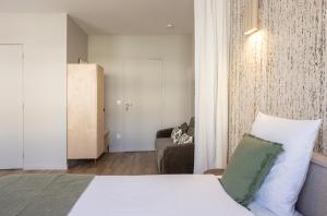 a hotel room with a bed and a couch at Studio moderne et climatisé - proche Paris in Le Pré-Saint-Gervais