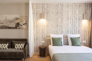 a hotel room with a bed and a couch at Studio moderne et climatisé - proche Paris in Le Pré-Saint-Gervais