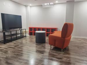 a living room with a chair and a television at Cozy Suite! Separate Entry, 1 Parking in Newmarket