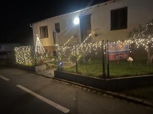 a fence with christmas lights in front of a house at Aux cigogneaux in Guémar