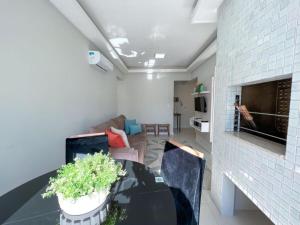 ein Wohnzimmer mit einem Tisch und einem Sofa in der Unterkunft Apartmento próximo ao mar in Capão da Canoa + 3 Fotos
