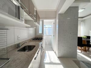 una cucina con lavandino e piano cottura di Apartmento próximo ao mar a Capão da Canoa Altre 3 foto