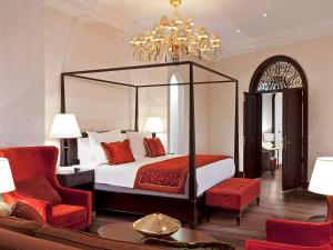 
a hotel room with a large bed and two lamps at Sofitel Legend Old Cataract in Aswan
