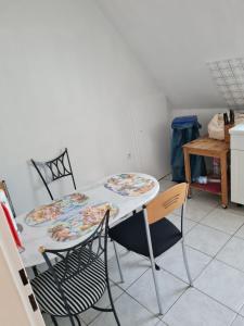 a table with two chairs and a table with plates on it at Ferienwohnung Quickborn in Quickborn