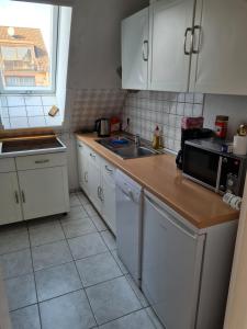 a kitchen with white cabinets and a sink at Ferienwohnung Quickborn in Quickborn +5 photos