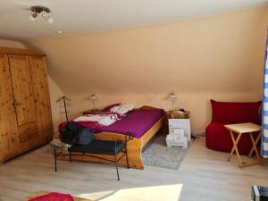 a bedroom with a bed and a chair in it at Ferienwohnung Quickborn in Quickborn