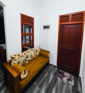 a wooden couch in a room with a door at Meadow view unawatuna in Galle