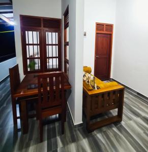 a dining room with a table and chairs and a door at Meadow view unawatuna in Galle