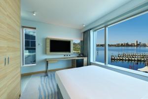 ein Schlafzimmer mit einem großen Bett und einem großen Fenster in der Unterkunft Doubletree By Hilton Perth Waterfront in Perth