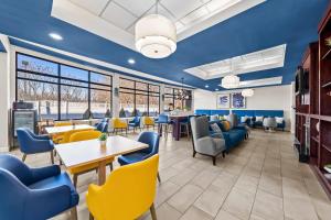 een restaurant met blauwe muren en gele stoelen bij Comfort Inn & Suites Plainville-Foxboro in Plainville