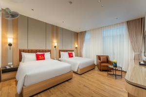 a hotel room with two beds and a chair at Lam Anh Hotel 9 Him Lam Vạn Phúc in Hà Ðông +22 photos