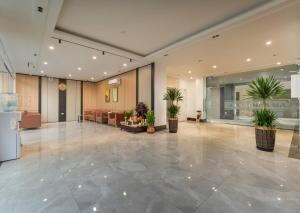 an empty lobby with potted plants in a building at Lam Anh Hotel 9 Him Lam Vạn Phúc in Hà Ðông