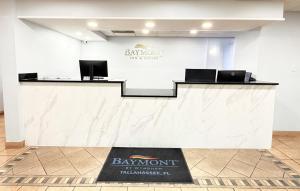 a lobby with a counter with two laptops on it at Baymont by Wyndham Tallahassee in Tallahassee