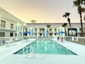 a swimming pool in front of a large building at Baymont by Wyndham Tallahassee in Tallahassee +25 photos