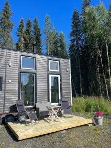 a tiny house with two chairs and a deck at Saagala Village in Tornio