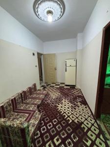 an empty room with a bed and a refrigerator at Alaraby 2 in Az Zaytīyah