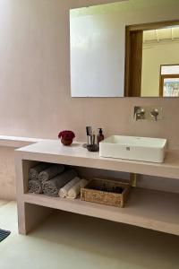 a bathroom with a white sink and a mirror at Madi House in Matara