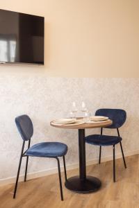 a table with two chairs and a table with glasses on it at Charming and air-conditioned - Close to Paris in Le Pré-Saint-Gervais