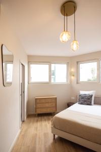 a bedroom with a bed and two windows at Charming and air-conditioned - Close to Paris in Le Pré-Saint-Gervais