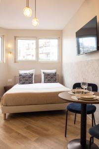 a bedroom with a bed and a table with chairs at Charming and air-conditioned - Close to Paris in Le Pré-Saint-Gervais