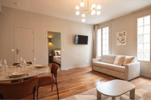 a living room with a table and a couch at Charming and spacious air-conditioned apartment in Le Pré-Saint-Gervais