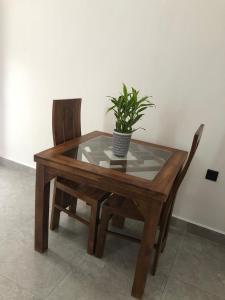 a wooden table with a potted plant and two chairs at The BLISS Mihiripenna in Talpe